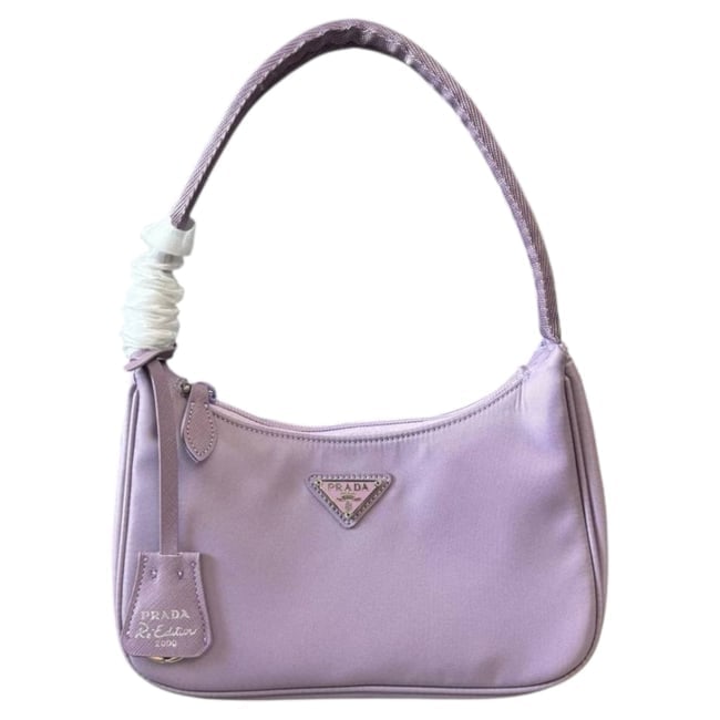 Prada Purple/Silver Re-Edition Nylon Mini Beaute Bag & Original Box: • Prada • Re-Edition • Purple • Silver Tone Hardware • Mini Nylon Bag • Zip Closure • Single Strap • Interior Slip Pocket • Front Logo • Original