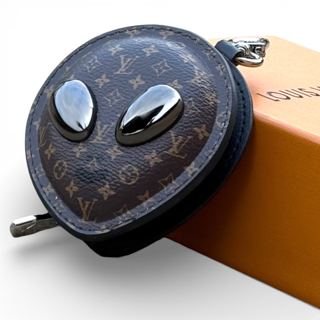 Louis Vuitton Brown Monogram Alien Bag Charm/Beaute Key Chain: • Louis Vuitton • Brown Monogram • Bag Charm/Beaute Key Chain • Design: Alien • Gold Tone Hardware • Zip Closure • Hooking Latch • Zip Closure • Ear Bud/Ai