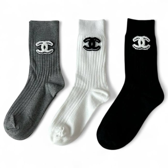 CHANEL 3Pc Signature White, Grey, & Black Trio Beaute Sock Set: • Indulge in luxury with this exquisite set of Chanel socks, combining luxury and comfort these are perfect for adding a touch of style to any wardrobe. • Included Colors: - Black - White -