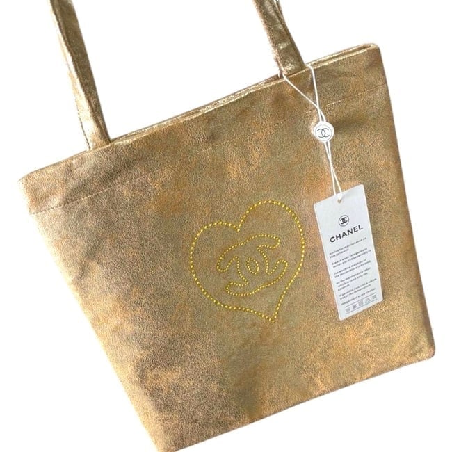 CHANEL Shimmer Detailed Front Logo U.L Beaute Tote: • CHANEL • Tote • Tan Multicolor • Shimmer Detail • Canvas • Front Logo • Double Handles • Uniform Line • Snap Closure • 11" x 11.8" (in)