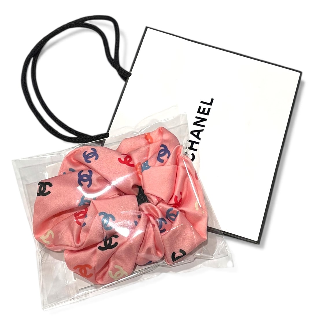 CHANEL Pink/Multicolor Logo Hair Scrunchy & Gift Bag: • CHANEL • Hair Scrunchy/Tie • Pink • Silk • Multicolor CC Logo • Original Gift Bag Included • Makeup/Diffusion Line: Please note that gwp/beaute items are not sold