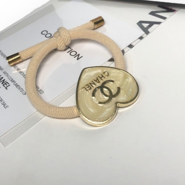 CHANEL Metallic White/Gold Heart Shaped Hair Tie & Gift Bag: • CHANEL • L.A. Collection • Metallic White • Gold Tone Hardware • Hair Tie • Shape: Heart • Gold Trim • Front CC/CHANEL Logo • Unopened/In Original