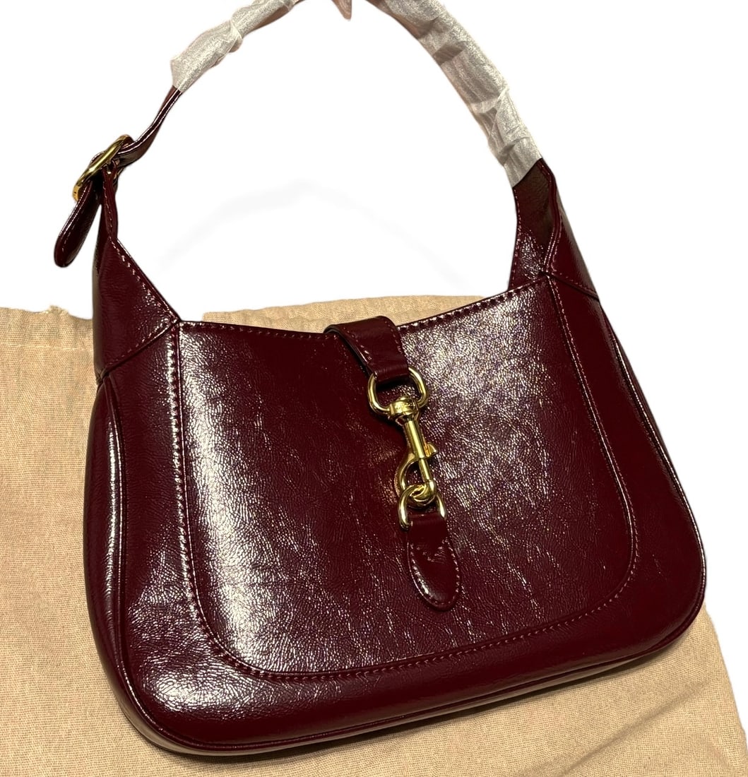Gucci Burgundy/Gold Jacki Beaute Shoulder Bag & Dust Bag: • Gucci • Jacki • Burgundy • Gold Tone Hardware • Single Strap • Shoulder Carry • Hook Closure • Adjustable Strap • Top Handle For Optional Carry &bull