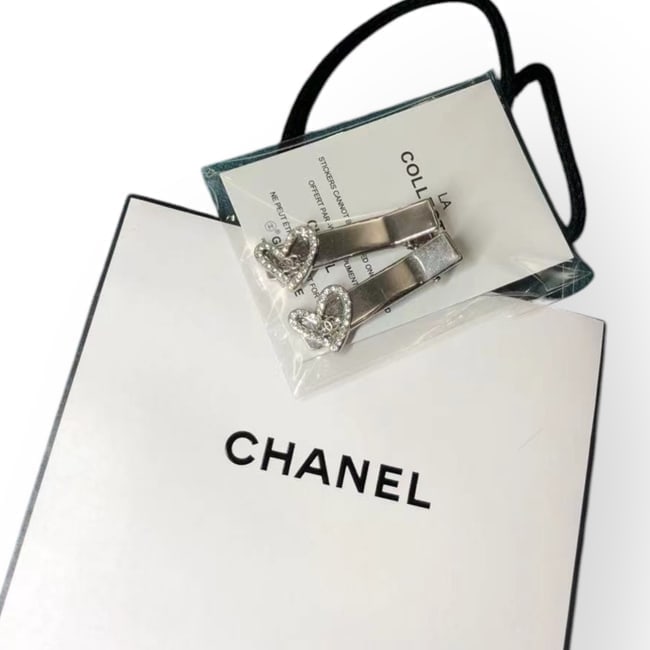 CHANEL 2Pc Silver/Heart Rhinestone Hair Clips &Gift Bag: • CHANEL • Gabrielle • 2Pc Set • Hair Clips • Silver Tone Hardware • White Rhinestone Heart Accents • L.A Collection • Unopened/In Original Packaging • Ori