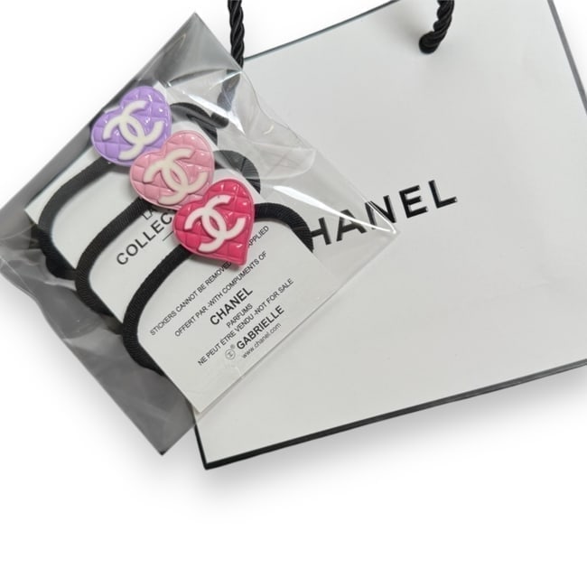CHANEL 3PC Quilted Heart/CC Logo Hair Ties & Gift Bag: • CHANEL • 3 Piece • Purple, Pink, & Hot Pink • Quilted Pattern • L.A Collection • Hair Ties • Shape: Heart • White CC Logo • Unopened/In Original Packagin