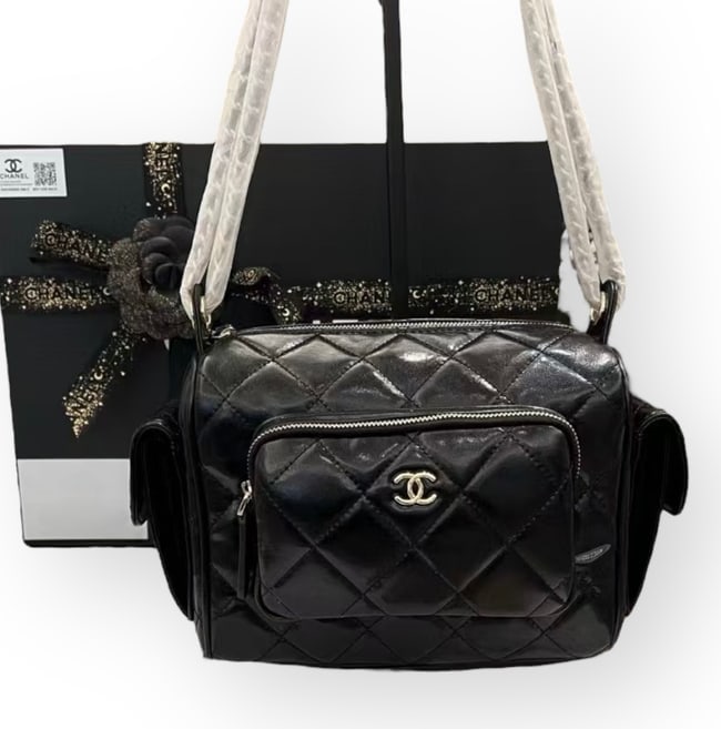 CHANEL Black/Silver Quilted Hobo Beaute Case & Original Gift Bag: • CHANEL • Black • Quilted Pattern • Hobo Case Shoulder Bag • Silver Tone Hardware • Front Zip Pocket • Exterior Rear Zip Pocket • Intertwined Leather Chain Str