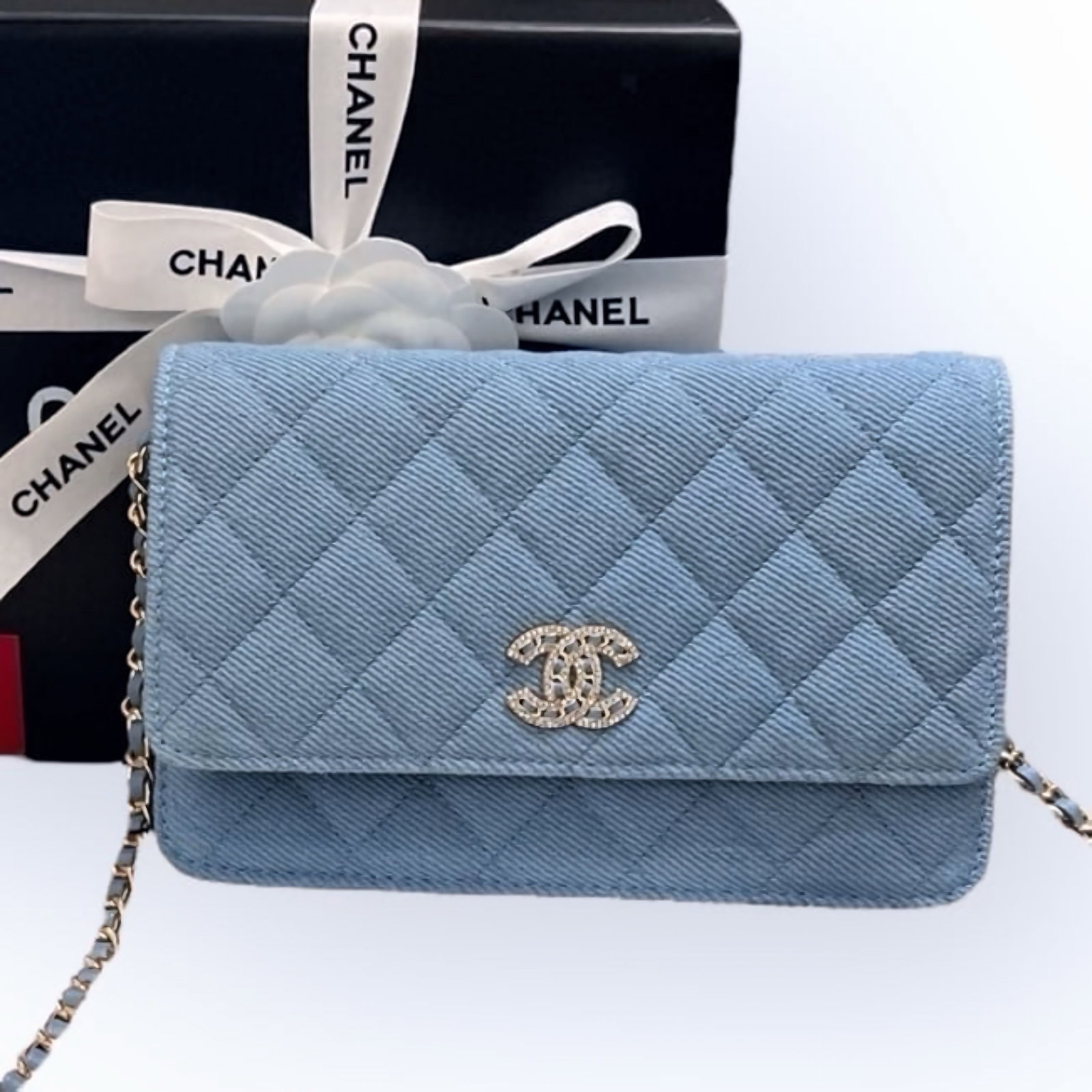 CHANEL Quilted Blue/Rhinestone CC Wallet On Chain Beaute Bag & Original Box: • CHANEL • Light Blue • Denim • Quilted Pattern • Wallet On Chain (WOC) • Silver Tone Hardware • Intertwined Leather Chain Strap • Snap Closure • Front Rhi
