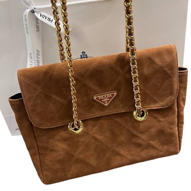 Prada Brown/Gold Hobo Parachute Chain Beaute Bag & Original Gift Bag: • Prada • Hobo Parachute Chain • Brown • Gold Tone Hardware • Intertwined Leather Chain Strap • Snap Closure • Quilted Pattern • Interior Zip Pocket • 2 Wa
