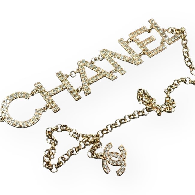 CHANEL Gold/Rhinestone Detailed Logo & CC Charm Beaute Belt & Gift Bag: • CHANEL • Gabrielle • L.A. Collection • Gold Tone Hardware • Chain Belt • White Rhinestone Front CHANEL Logo • Logo Letters Are 1.5" (in) • Adjustable • W
