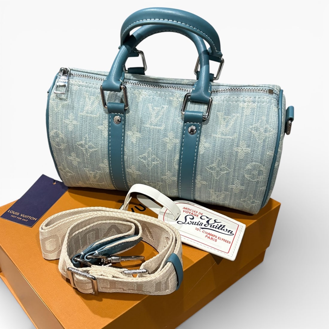 Louis Vuitton Denim/Blue Keepall Bandouliere 25 Pillow Beaute Bag & Original Box: • Louis Vuitton • Keepall Bandouliere 25 • Pillow Bag • Denim • Monogram Pattern • Blue Accents/Trim • Removable Strap Included • Zip Closure • Silver Tone