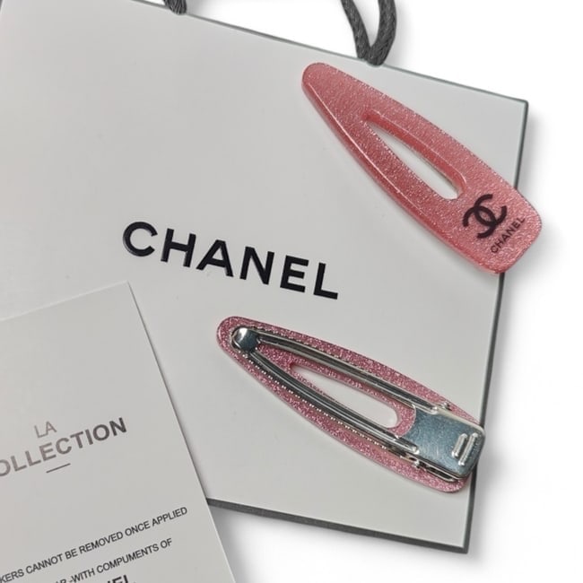 CHANEL2Pc Pink Shimmer/Black CC Hair Clips & Original Gift Bag: • CHANEL • L.A. Collection • Gabrielle • 2Pc Set • Hair Clips • Pink Shimmer • Black CC Logo • Silver Tone Hardware • Shape: Regular • Unopened/In