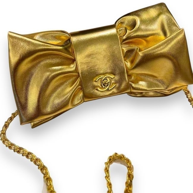 Chanel 24B Metallic Gold Bow Clutch Beaute Bag On Chain & Original Box: • CHANEL • Shape: Bow • Metallic Gold • Clutch or Shoulder Carry • Gold Tone Hardware • Signature CC Twist Lock Closure • Single Strap • Original Box & Dust Bag