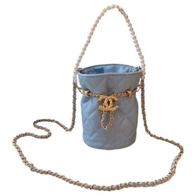 CHANEL Baby Blue/Gold Mini Drawstring Beaute Bag & Original Box: • CHANEL • Baby Blue • Quilted Pattern • Gold Tone Hardware • Mini Drawstring Bag • Drawstring Closure • Beveled CC Logo Charm On Strap • Removable Pearl Strap