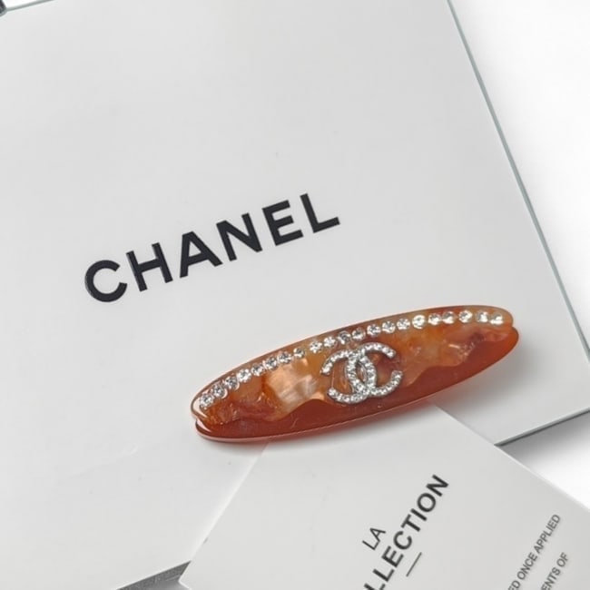 CHANEL Lg Brown Shimmer/Rhinestone Detailed Long Oval Hair Clip & Gift Bag: • CHANEL • Gabrielle • Hair Clip • Brown Shimmer • Rhinestone Accents • Rhinestone CC Logo • Gold Tone Hardware • Shape: Long Oval • Size: Large • L.A