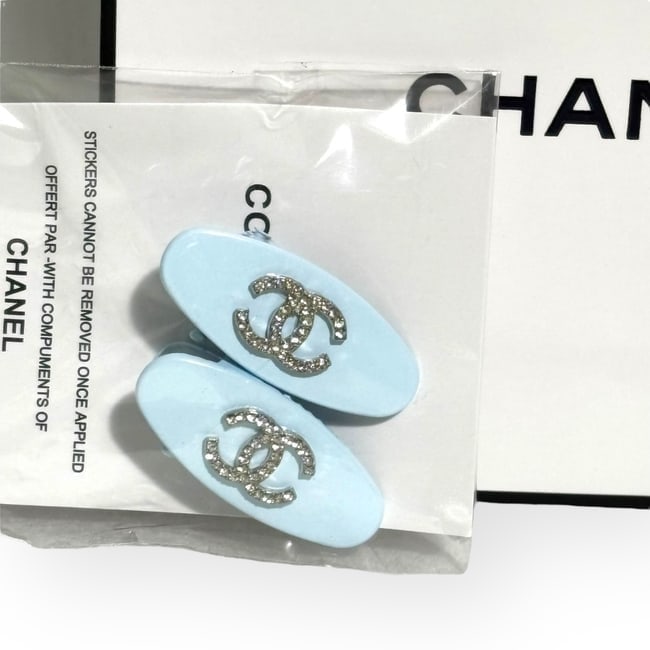 CHANEL 2Pc Lg Baby Blue/Rhinestone CC Oval Hair Clips & Gift Bag: • CHANEL • Collection: L.A. Collection • Style: Gabrielle • Type: Hair Clips • Set: 2Pc Set • Color: Baby Blue • Detail: White Rhinestone CC Logo • Shape: Oval