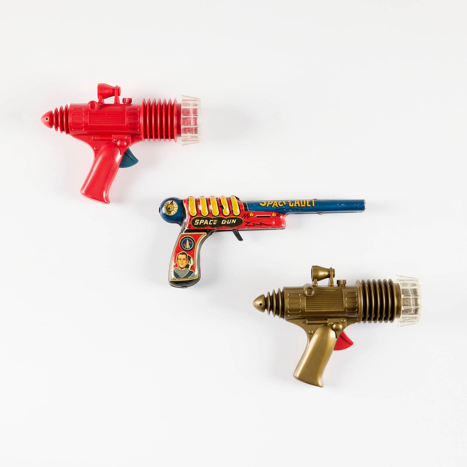 Three Marx Tom Corbett Space Cadet and Rex Mars Planet Patrol Ray Guns: Three Marx Tom Corbett Space Cadet and Rex Mars Planet Patrol Ray Guns molded plastic, transfer print on metal, zinc-plated steel 4.5 h x 9.875 w x 1.25 d in (11 x 25 x 3 cm) 5.5 h x 7.5 w x 2.25 d in