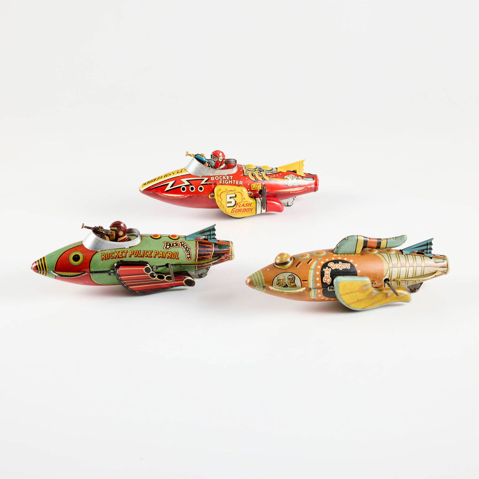 Three Marx Toys Tin Wind-Up Buck Rogers & Flash Gordon Sparkling Rocket Fighter Ship: Three Marx Toys Tin Wind-Up Buck Rogers & Flash Gordon Sparkling Rocket Fighter Ship transfer print on metal 4.5 h x 4 w x 12 d in (11 x 10 x 30 cm) Printed manufacturer's mark to two examples 'Buck R