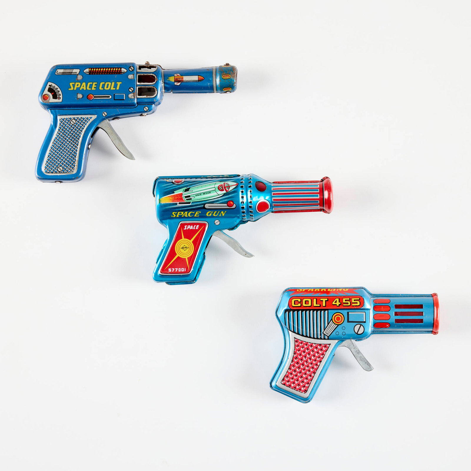 Three Japanese Tin Ray Guns with Original Box: Three Japanese Tin Ray Guns with Original Box transfer print on metal, zinc-plated steel 3.875 h x 6.375 w x 1 d in (10 x 16 x 3 cm) 3.5 h x 5.75 w x 1.25 d in (9 x 15 x 3 cm) 3.75 h x 5.25 w x 1.25 d