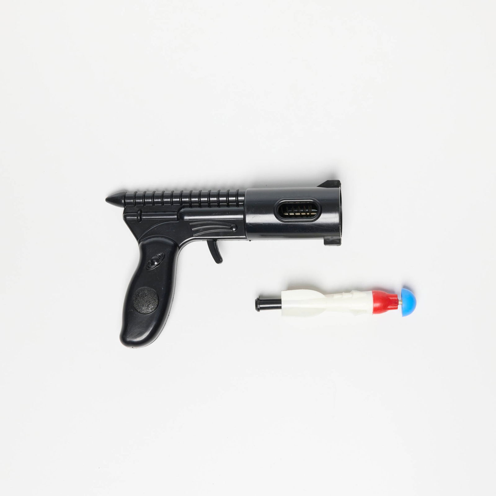 Empire Plastics Corp. Rocketeer Dart Gun with Original Card: Empire Plastics Corp. Rocketeer Dart Gun with Original Card molded plastic, rubber 5 h x 6.75 w x 1.75 d in (13 x 17 x 4 cm) Sold with original packaging and one dart. Printed manufacturer's mark to p