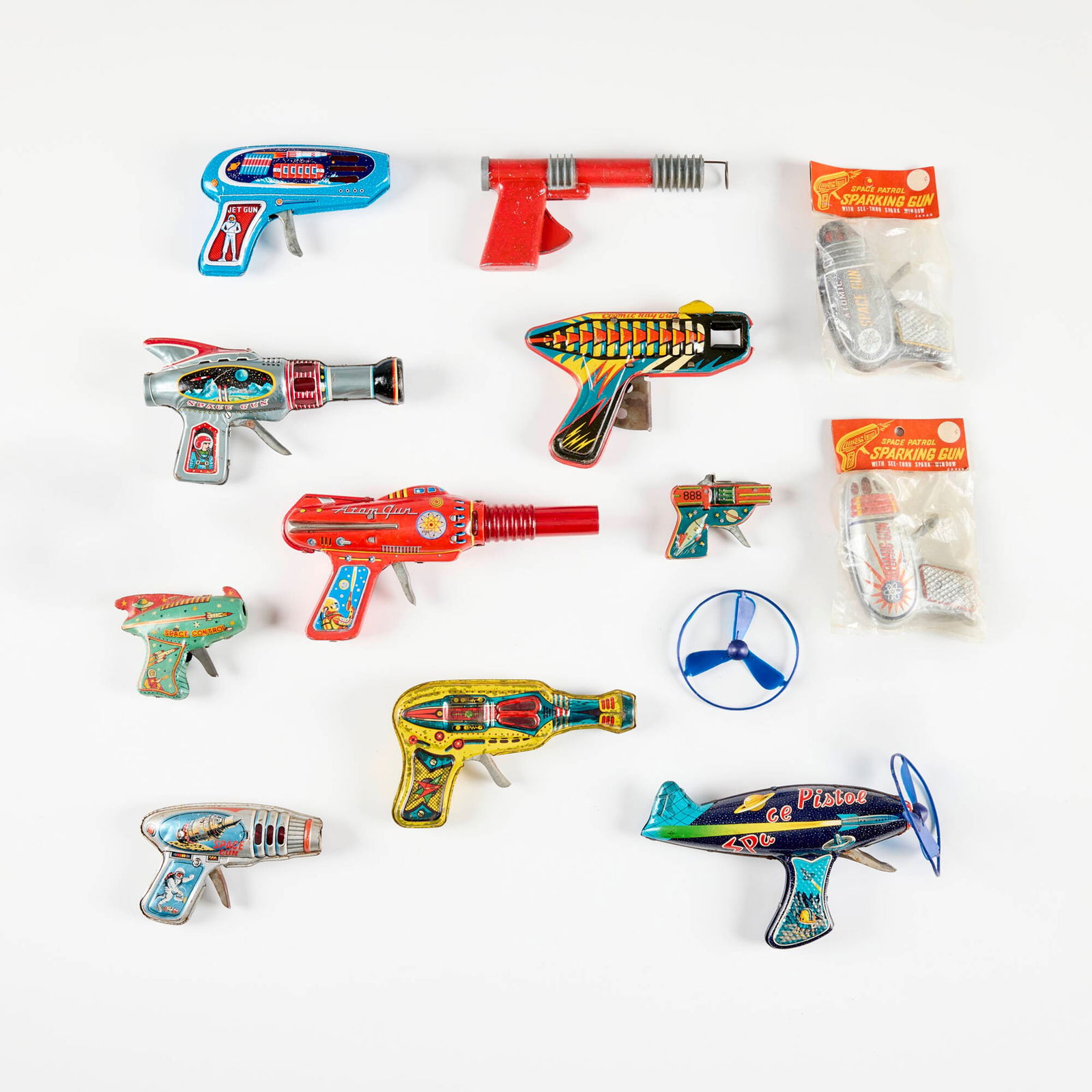 Twelve Vintage Tin Ray Guns: Twelve Vintage Tin Ray Guns transfer print on metal, zinc-plated steel, molded plastic. largest: 4.5 h x 39 w x 1.75 d in (11 x 99 x 4 cm) smallest: 2.5 h x 3 w x 0.75 d in (6 x 8 x 2 cm) Manufacturer