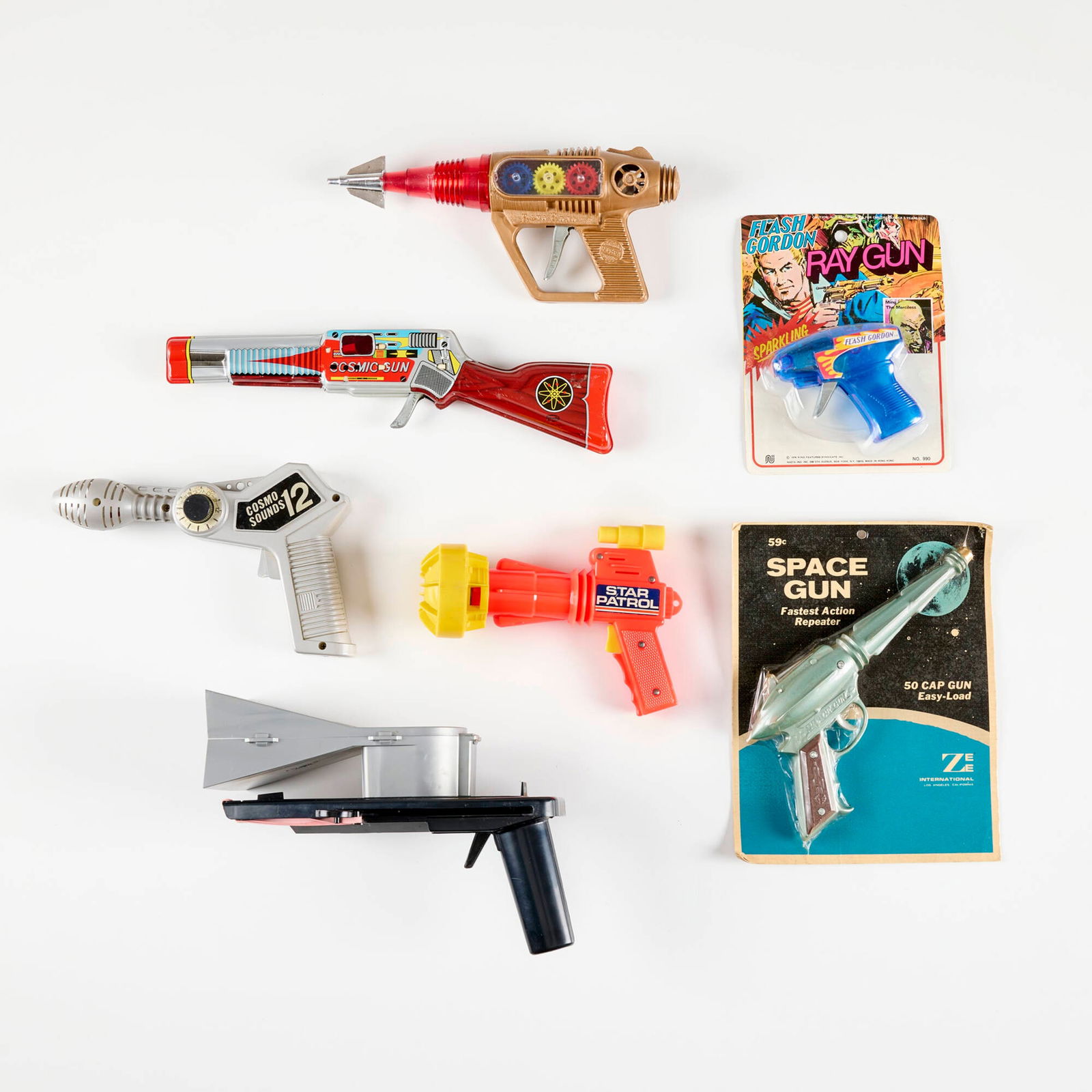 Seven Vintage Ray Guns with Original Box: Seven Vintage Ray Guns with Original Box plastic, transfer-printed metal, printed paper largest: 5.5 h x 10 w x 5.5 d in (14 x 25 x 14 cm) smallest: 8 h x 6 w x 1.5 d in (20 x 15 x 4 cm) Each example