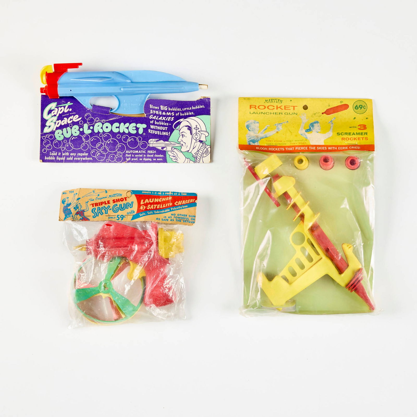 Three Early American Plastic Ray Guns Factory Sealed: Three Early American Plastic Ray Guns Factory Sealed plastic, rubber 4.5 h x 9.25 w x 1.125 d in (11 x 23 x 3 cm) 5.25 h x 6.25 w x 3.5 d in (13 x 16 x 9 cm) 2.25 h x 7.375 w x 1.375 d in (6 x 19 x 3