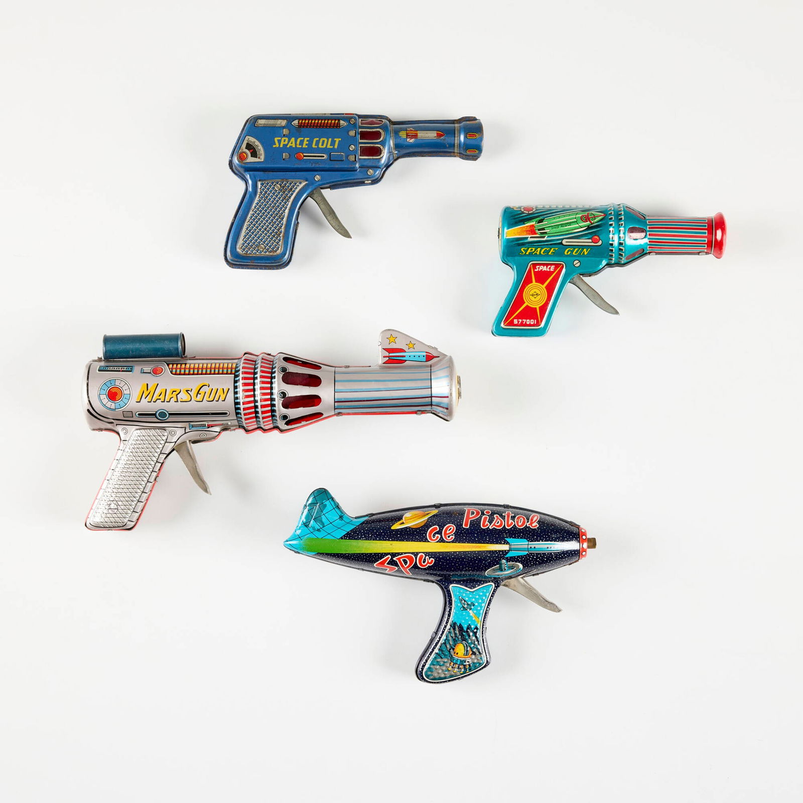 Four Vintage Japanese Tin Ray Guns: Four Vintage Japanese Tin Ray Guns transfer print on metal largest: 5 h x 9.75 w x 2 d in (13 x 25 x 5 cm) smallest: 3.25 h x 6 w x 1.5 d in (8 x 15 x 4 cm) Printed manufacturer's mark to each example