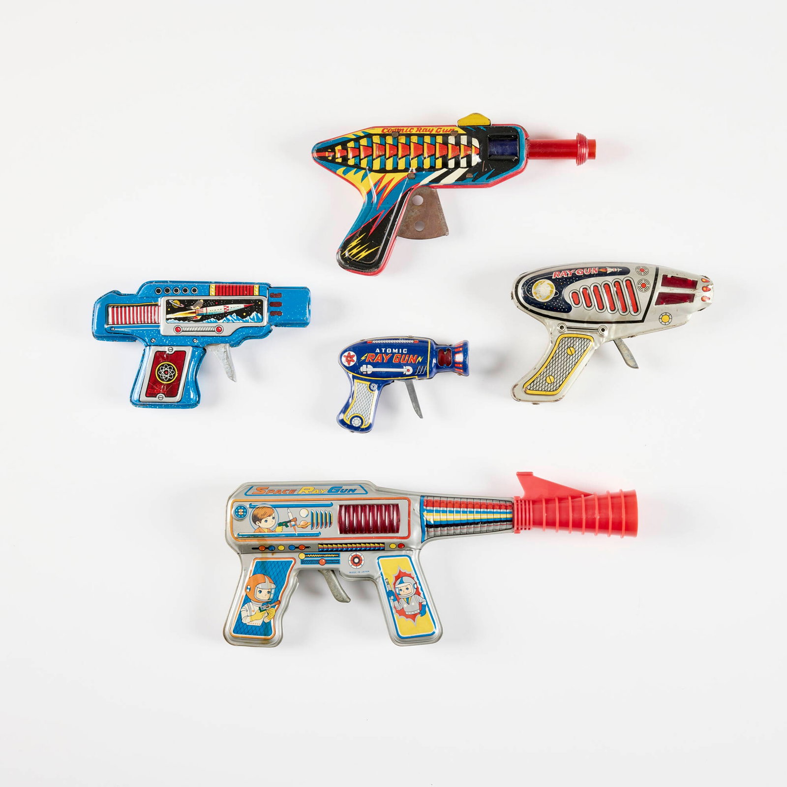 Five Japanese Tin Ray Guns: Five Japanese Tin Ray Guns transfer print on metal, molded plastic, zinc-plated steel largest: 5 h x 12.5 w x 1.375 d in (13 x 32 x 3 cm) smallest: 3 h x 4 w x 1 d in (8 x 10 x 3 cm) Manufacturer's ma