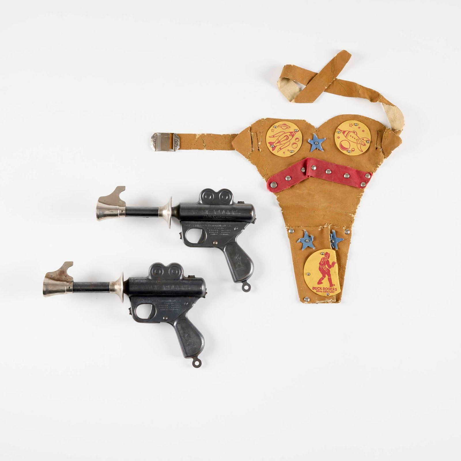 Two Daisy Buck Rogers Rocket Pistols: Two Daisy Buck Rogers Rocket Pistols patinated steel, nickel-plated steel, screenprint on vinyl gun: 6.5 h x 10 w x 2 d in (17 x 25 x 5 cm) holster: 10.75 h x 11 w x 0.25 d in (27 x 28 x 1 cm) One wit