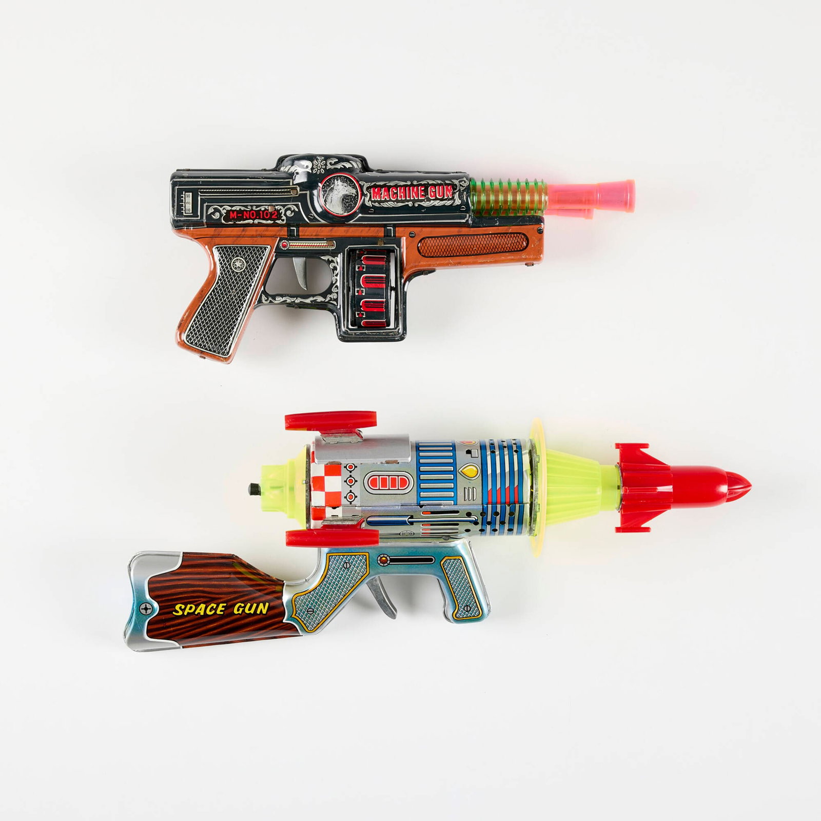 Two Japanese Tin Ray Gun Rifles: Two Japanese Tin Ray Gun Rifles transfer print on metal, molded plastic, zinc-plated steel 6.25 h x 17 w x 3.625 d in (16 x 43 x 9 cm) 5.75 h x 13 w in (15 x 33 cm) Space Gun box is a reproduction, no