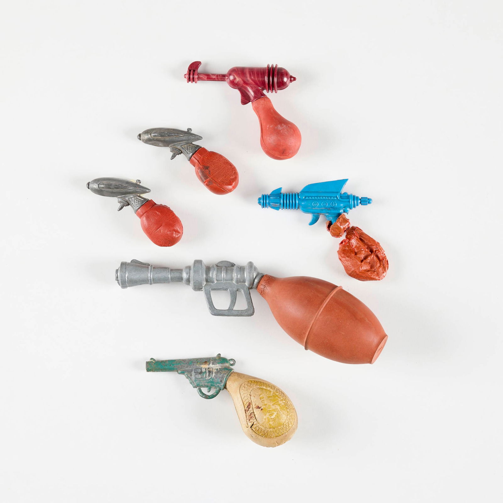 Six Early American Balloon Water Pistols: Six Early American Balloon Water Pistols cast zin-plated and enameled metal, molded plastic, rubber largest: 3 h x 8.5 w x 2 d in (8 x 22 x 5 cm) smallest: 2 h x 3.375 w in (5 x 9 cm) Condition Notes: