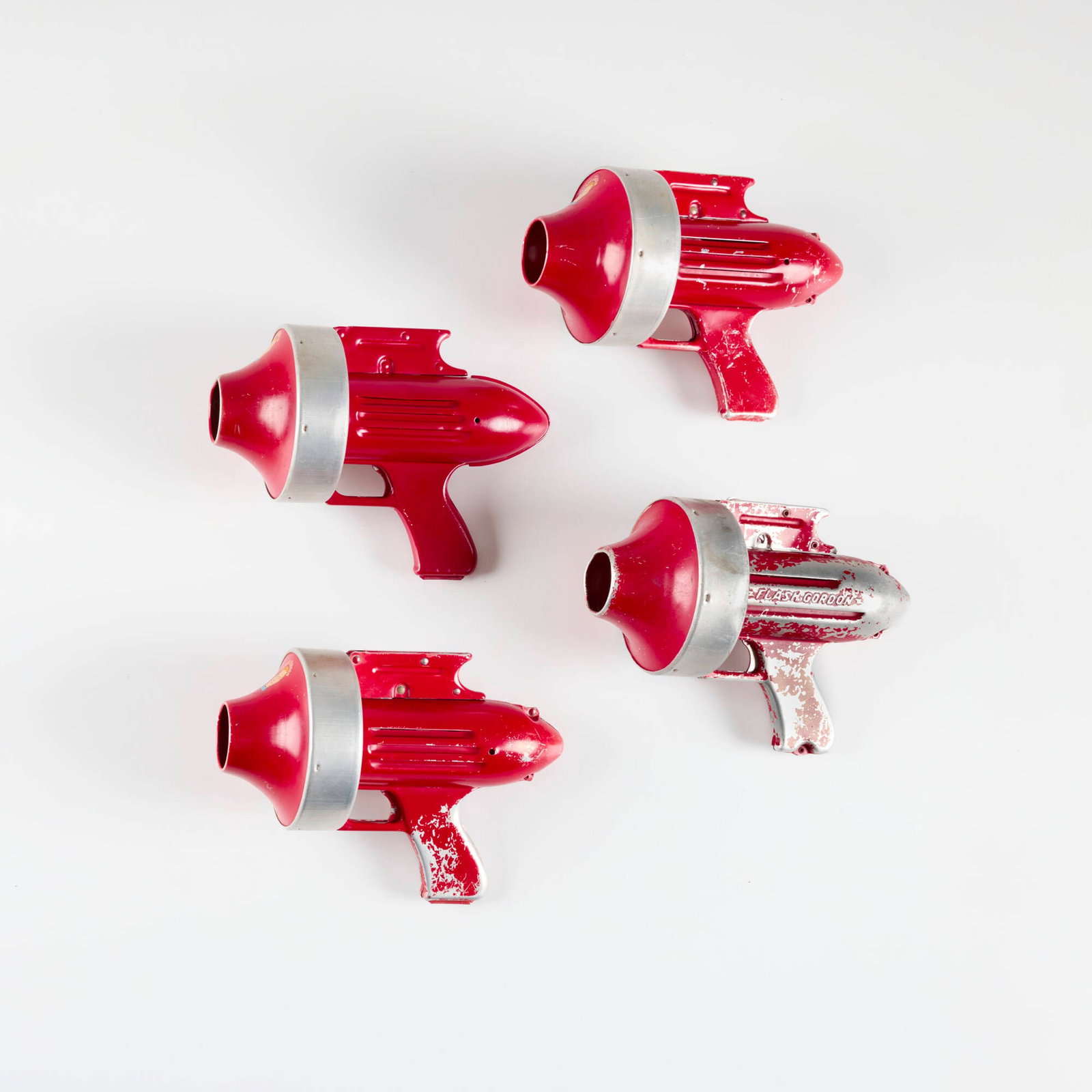 Four Budson Flash Gordon Air Ray Gun: Four Budson Flash Gordon Air Ray Gun enameled metal, aluminum ray gun: 7.5 h x 10.5 w x 5 d in (19 x 27 x 13 cm) box: 5.25 h x 10.25 w x 5.25 d in (13 x 26 x 13 cm) Manufacturer's mark to each example