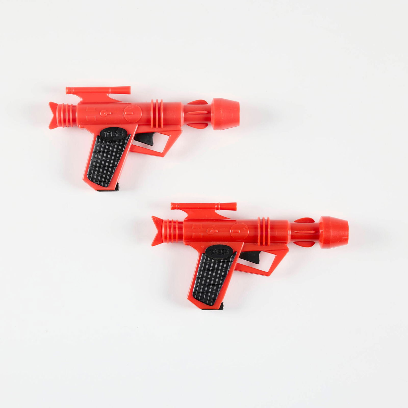 Two Vintage PEZ Ray Gun Dispensers: Two Vintage PEZ Ray Gun Dispensers molded plastic 4.5 h x 8.25 w x 1.125 d in (11 x 21 x 3 cm) Manufacturer's mark to each example. Condition Notes: Good to very good condition. Light wear exist