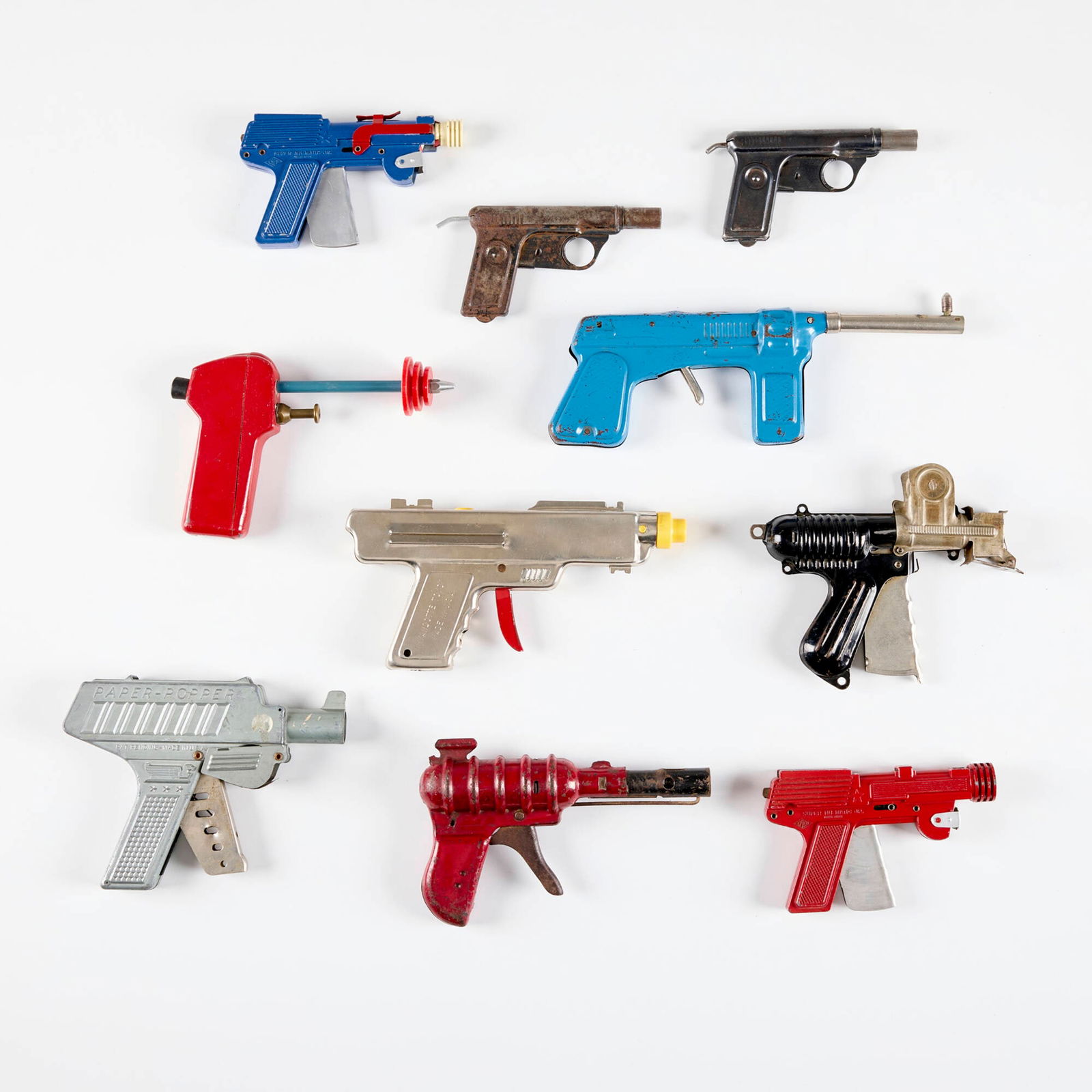 Ten Early Click and Pop Paper Toy Guns: Ten Early Click and Pop Paper Toy Guns enameled and chrome-plated metal, brass, plastic largest: 5 h x 6.75 w x 1 d in (13 x 17 x 3 cm) smallest: 3 h x 5.5 w x 0.625 d in (8 x 14 x 2 cm) Manufacturer'