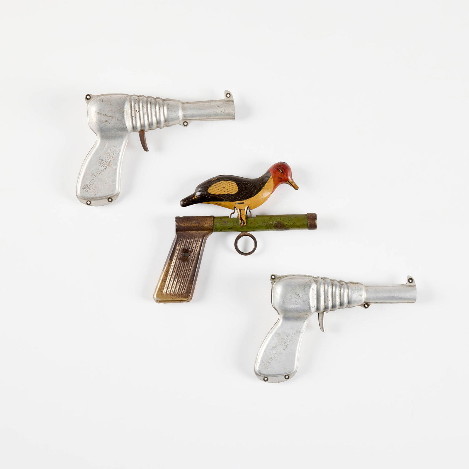 Three Early American Toy Guns: Three Early American Toy Guns enameled metal raygun: 4.25 h x 6.75 w x 1.25 d in (11 x 17 x 3 cm) the whoopee bird: 5 h x 6.75 w x 0.75 d in (13 x 17 x 2 cm) Impressed manufacturer's marks to each exa