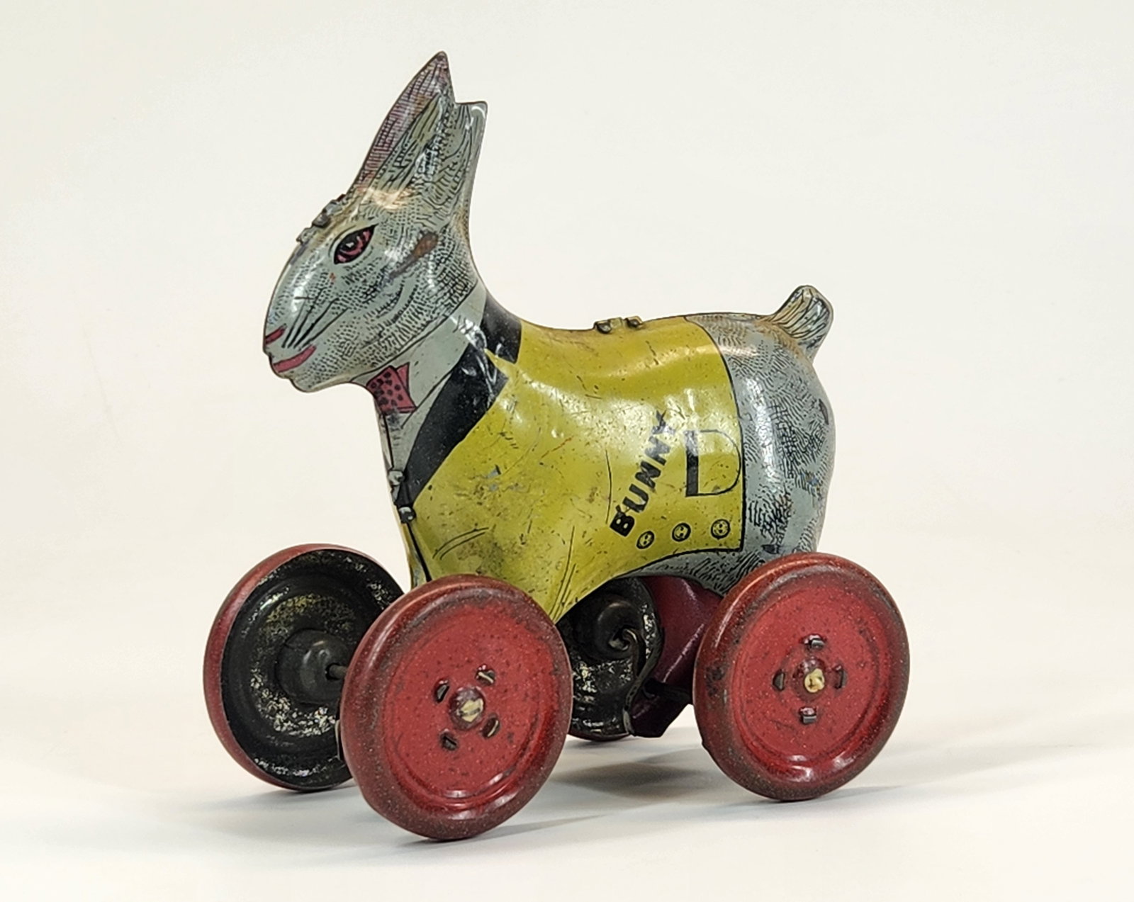 LINDSTROM TIN LITHO BUNNY ON WHEELS PUSH TOY: REMAINS IN GOOD CONDITION, SHOWING SOME TYPICAL WEAR.