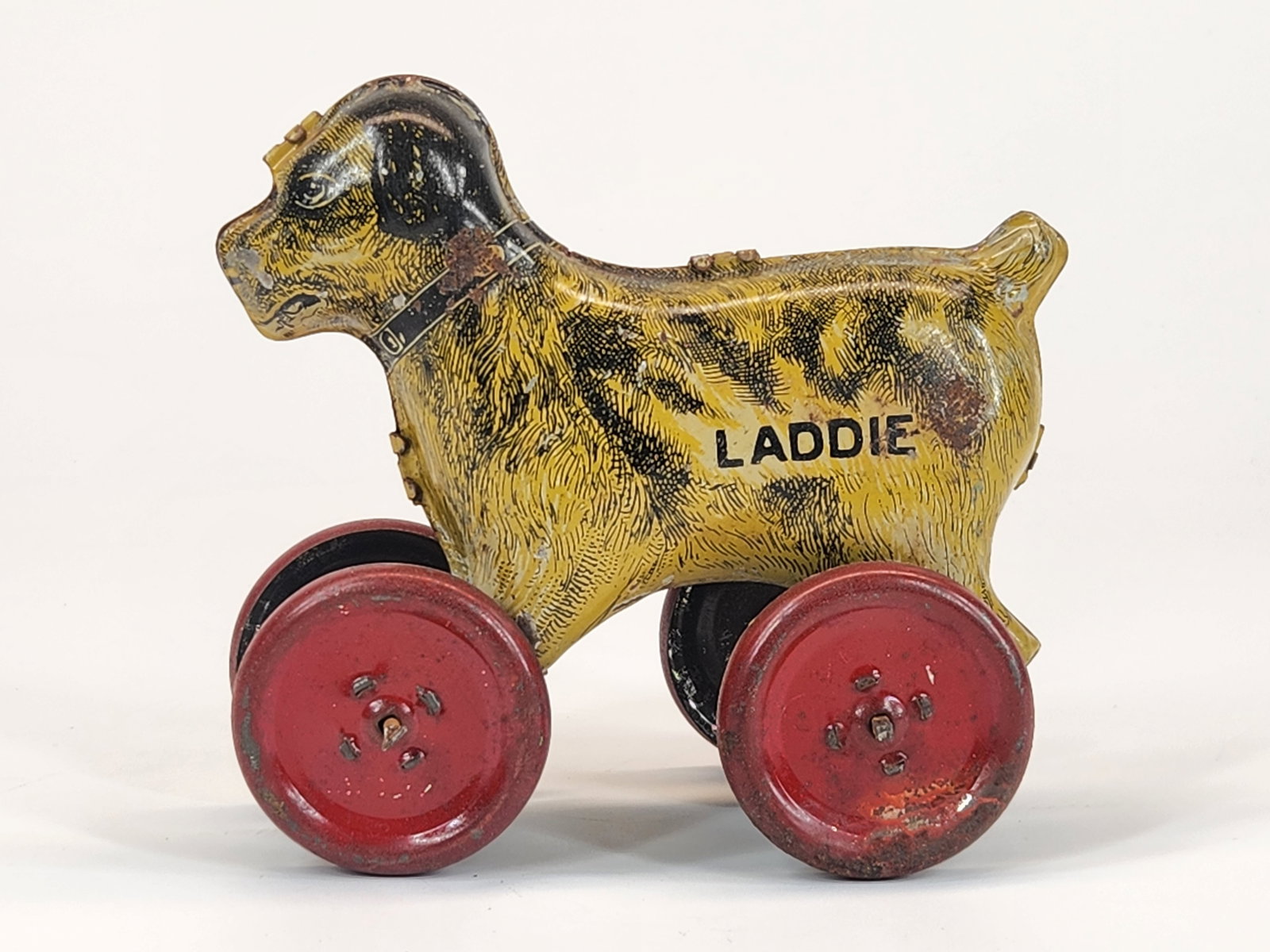 LINDSTROM TIN LITHO LADDIE DOG ON WHEELS PUSH: REMAINS IN GOOD CONDITION, SHOWING SOME TYPICAL WEAR.