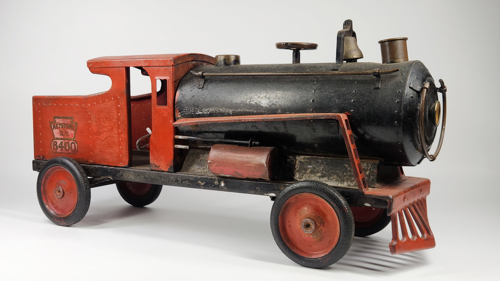 LARGE KEYSTONE PRESSED STEEL RIDE ON TRAIN: REMAINS IN FAIR CONDITION, SHOWING SOME WEAR. SHOWS AN OLD PAINT JOB. SOME OVER THE ORIGINAL LABEL. MEASURES APPROXIMATELY 26" LONG.