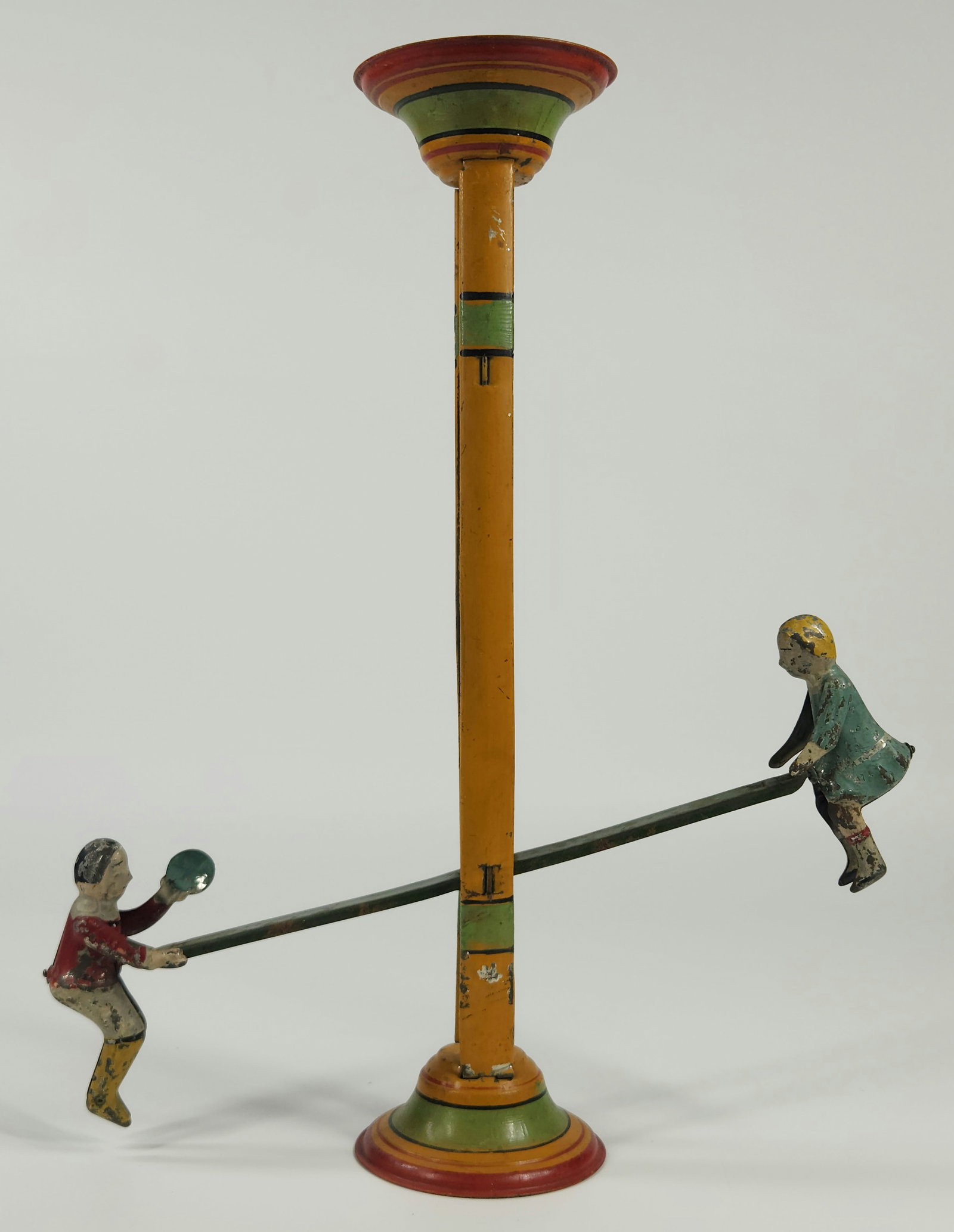 ANTIQUE GERMAN TIN PAINTED SEESAW TOY: REMAINS IN GOOD CONDITION, SHOWING SOME TYPICAL WEAR. SHOWS SOME PAINT WEAR. MEASURES APPROXIMATELY 14.5" TALL.