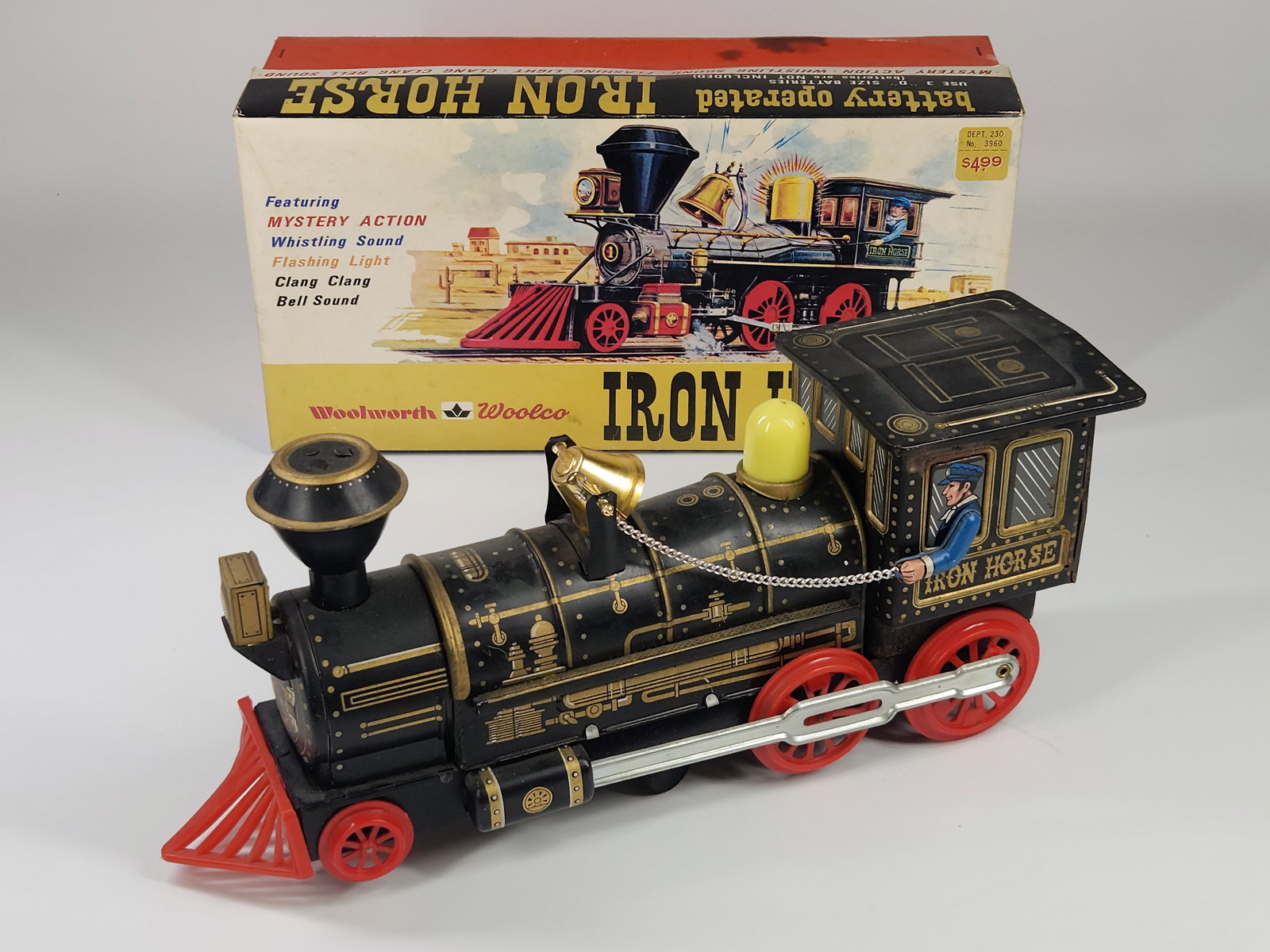 WOOLWORTH BATTERY OP IRON HORSE TRAIN W/ BOX: REMAINS IN FAIR CONDITION, SHOWING WEAR WITH SOME SURFACE RUST ON TOP. BOX SHOWING DAMAGE. DOES NOT RUN. MEASURES APPROXIMATELY 12" LONG.