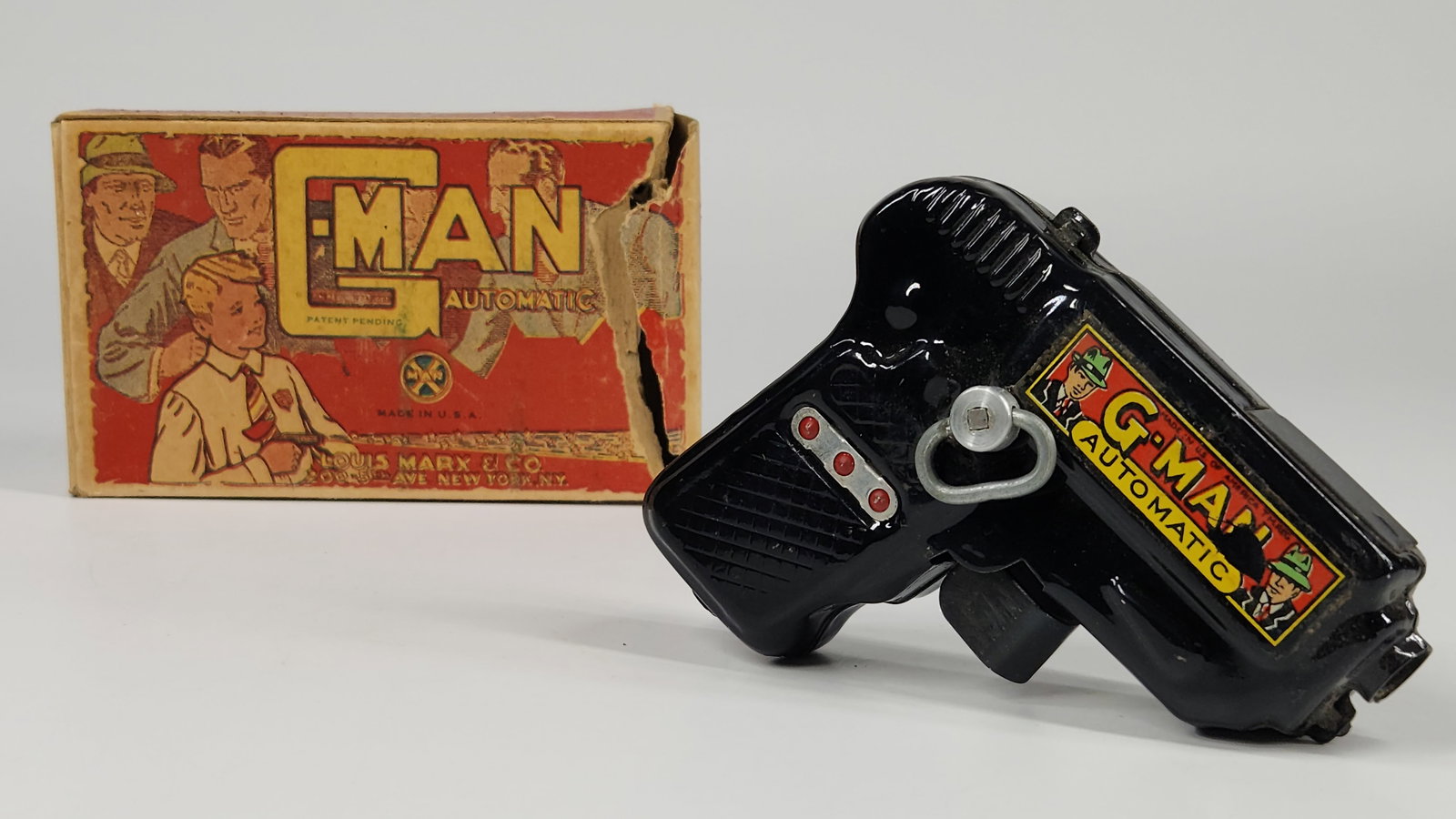 MARX G-MAN AUTOMATIC SPARKING PISTOL W/ BOX: REMAINS IN GOOD CONDITION, SHOWING SOME TYPICAL WEAR. WIND UP PISTOL WORKS. BOX SHOWING SOME WEAR WITH TORN END FLAP.