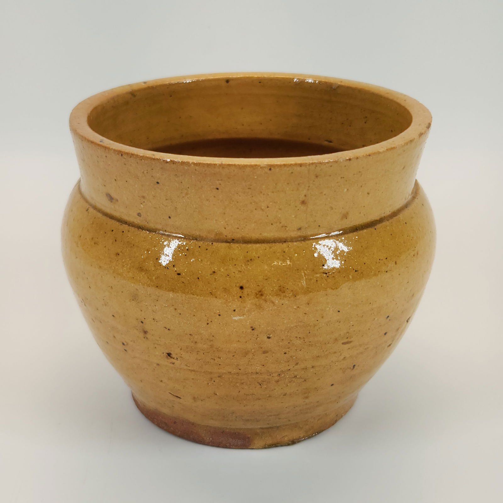 ANTIQUE YELLOW GLAZED STONEWARE CROCK: REMAINS IN FAIR CONDITION. HAS CRACK DOWN SIDE. MEASURES APPROXIMATELY 4" TALL.