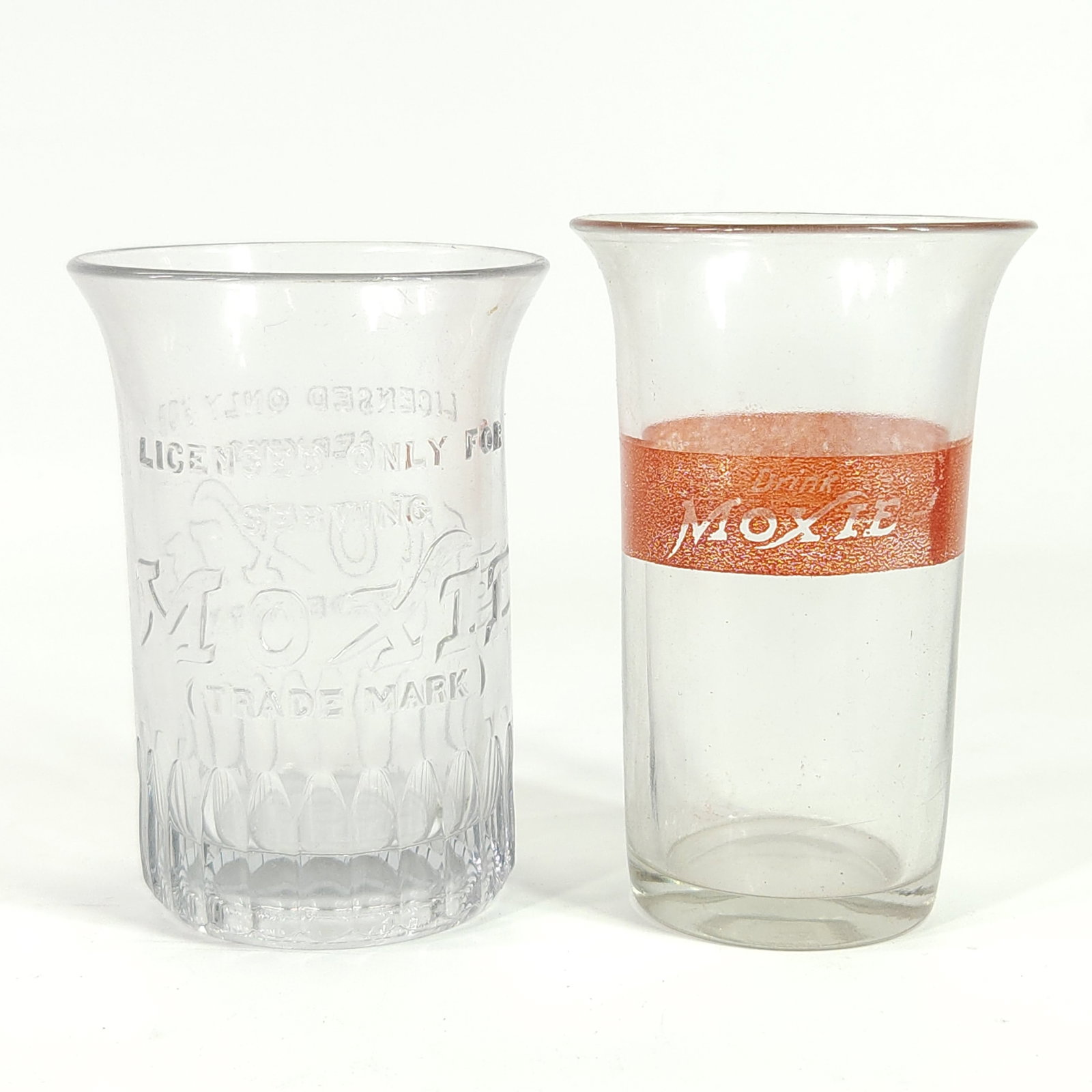 2) ANTIQUE MOXIE DRINKING GLASSES: BOTH REMAIN IN GOOD CONDITION, SHOWING SOME TYPICAL WEAR. NO CHIPS OR CRACKS.