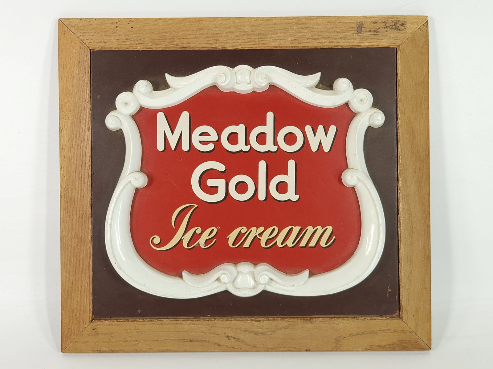 VINTAGE MEADOW GOLD ICE CREAM WALL PLAQUE: REMAINS IN GOOD CONDITION. FRAME SHOWING WEAR.