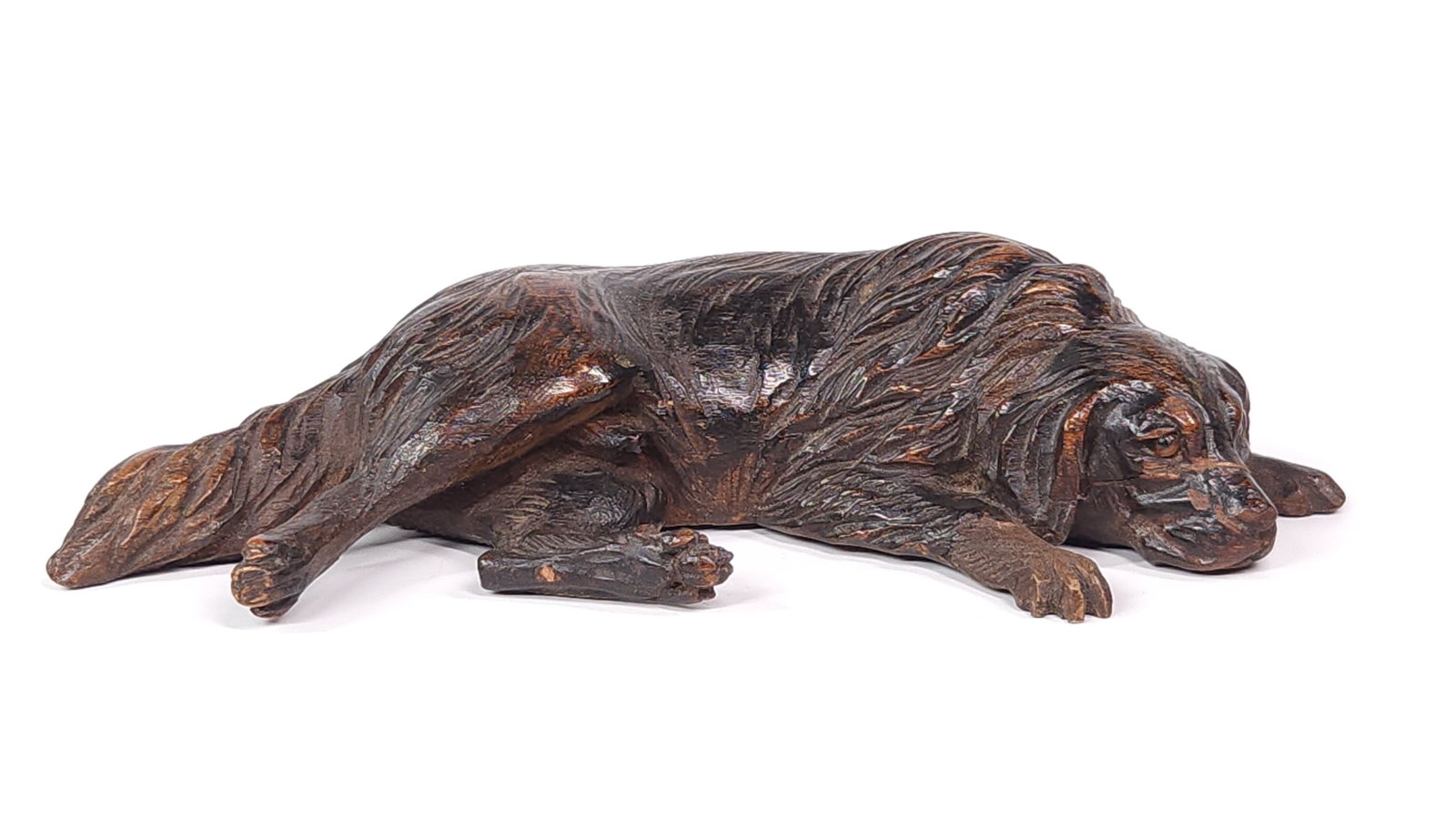ANTIQUE LAYING DOG WOOD CARVED BLACK FOREST FIGURINE: REMAINS IN GOOD CONDITION, SHOWING SOME TYPICAL WEAR CONSISTENT WITH AGE AND USE.