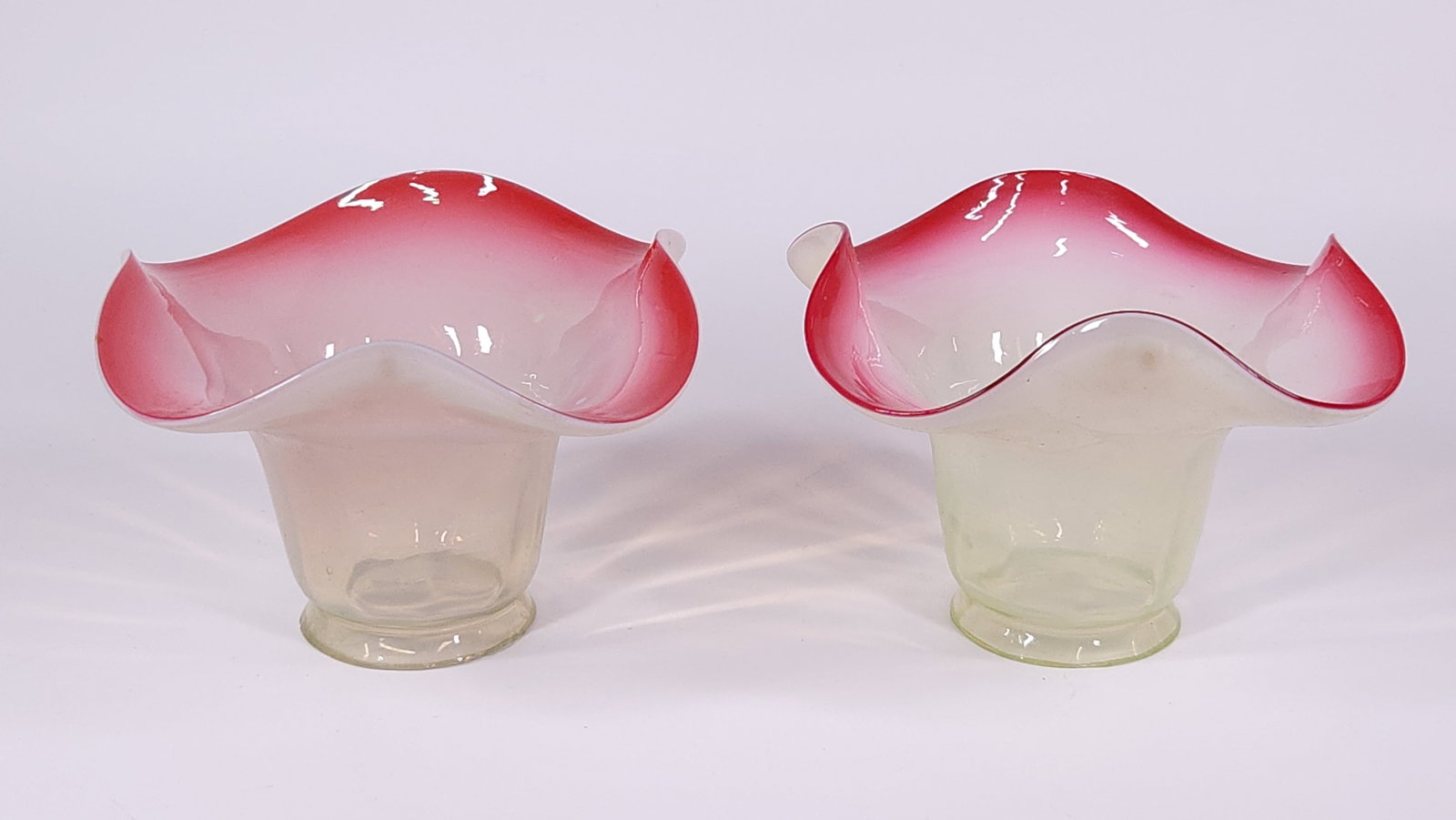 PAIR OF ANTIQUE PINK & WHITE GLASS LAMP SHADES: BOTH REMAIN IN GOOD CONDITION, SHOWING SOME TYPICAL WEAR. SMALL TINY CHIPS ALONG SHADE EDGE.