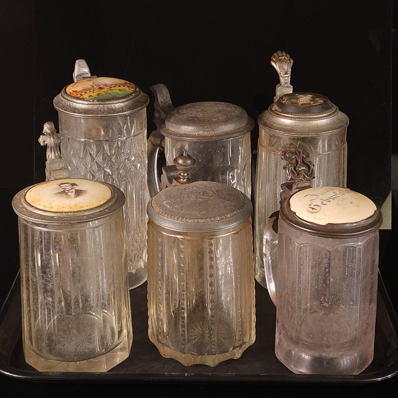 6) ANTIQUE GERMAN GLASS STEINS: ALL REMAIN IN FAIR TO GOOD CONDITION, SHOWING SOME TYPICAL WEAR. ALL NEED CLEANED.