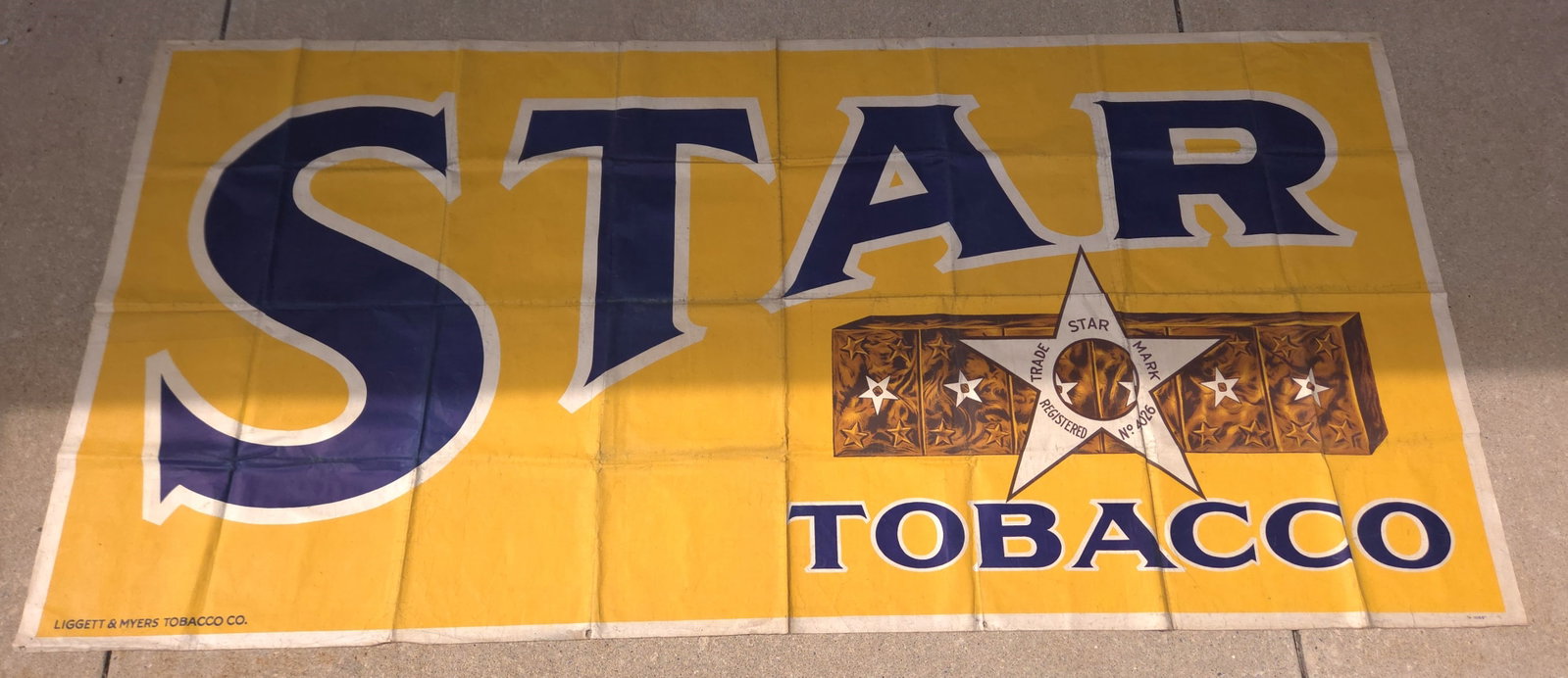 STAR TOBACCO ADVERTISING CANVAS BANNER: REMAINS IN GOOD CONDITION, SHOWING SOME SOFT SPOTS AT FOLD LINES. FOLD LINES SHOWING SOME STAINING ON BACK SIDE. MEASURES APPROXIMATELY 6 FEET BY 3 FEET.