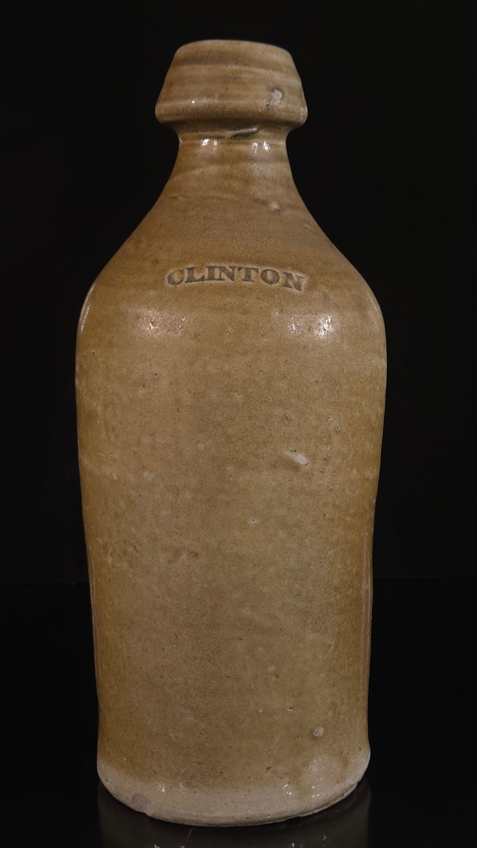 CLINTON STONEWARE BEER BOTTLE: REMAINS IN GOOD CONDITION, SHOWING SOME TYPICAL WEAR. 9.5 INCHES BY 4 INCHES.