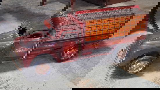 CONTEMPORARY DECORATIVE COCA COLA TRUCK: REMAINS IN GOOD CONDITION, SHOWING SOME TYPICAL DISPLAY WEAR. WHEELS LOOSE. MEASURES APPROXIMATELY 34" LONG BY 9" WIDE BY 12" TALL.